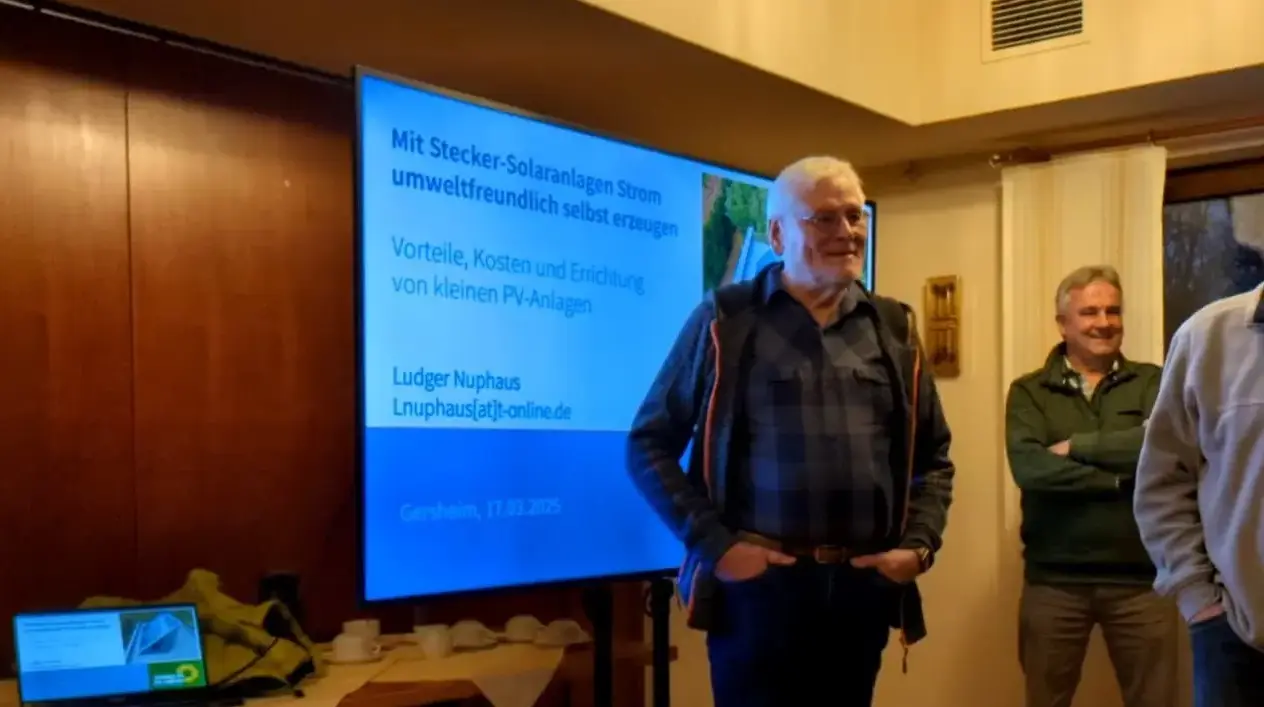 Vortragende vor einem Fernseher, der die Präsentation des Vortrags zeigt