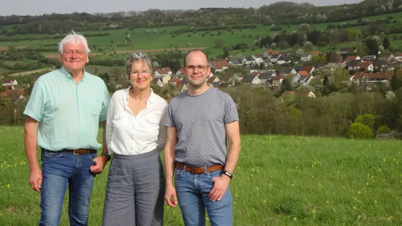 Die Kandidaten stehen nebeneinander. Dahinter ist Bliesdalheim im Frühling zu sehen.