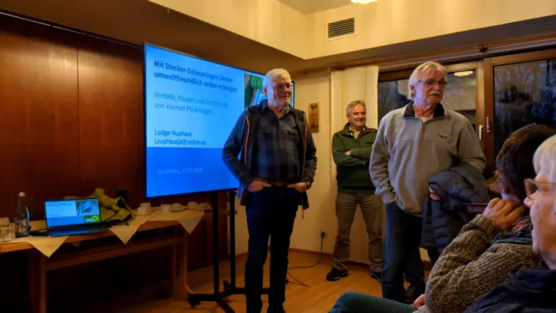 Vortragende vor einem Fernseher, der die Präsentation des Vortrags zeigt